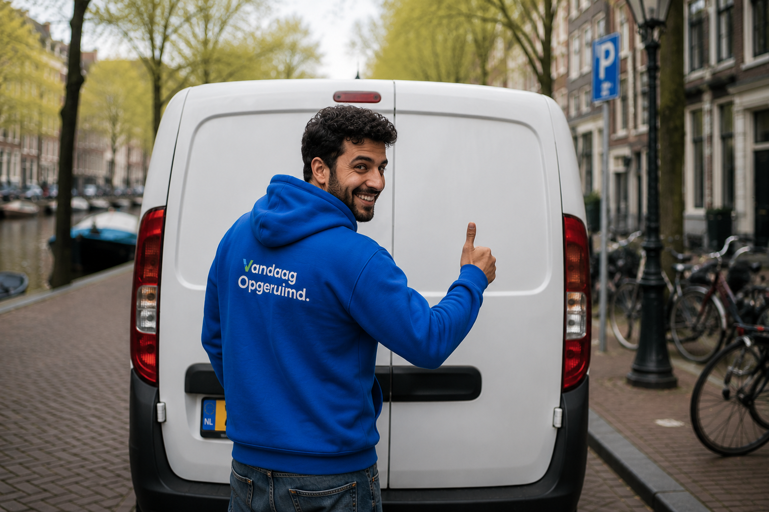 Medewerker van Vandaag Opgeruimd geeft een duim omhoog bij de bus in Amsterdam